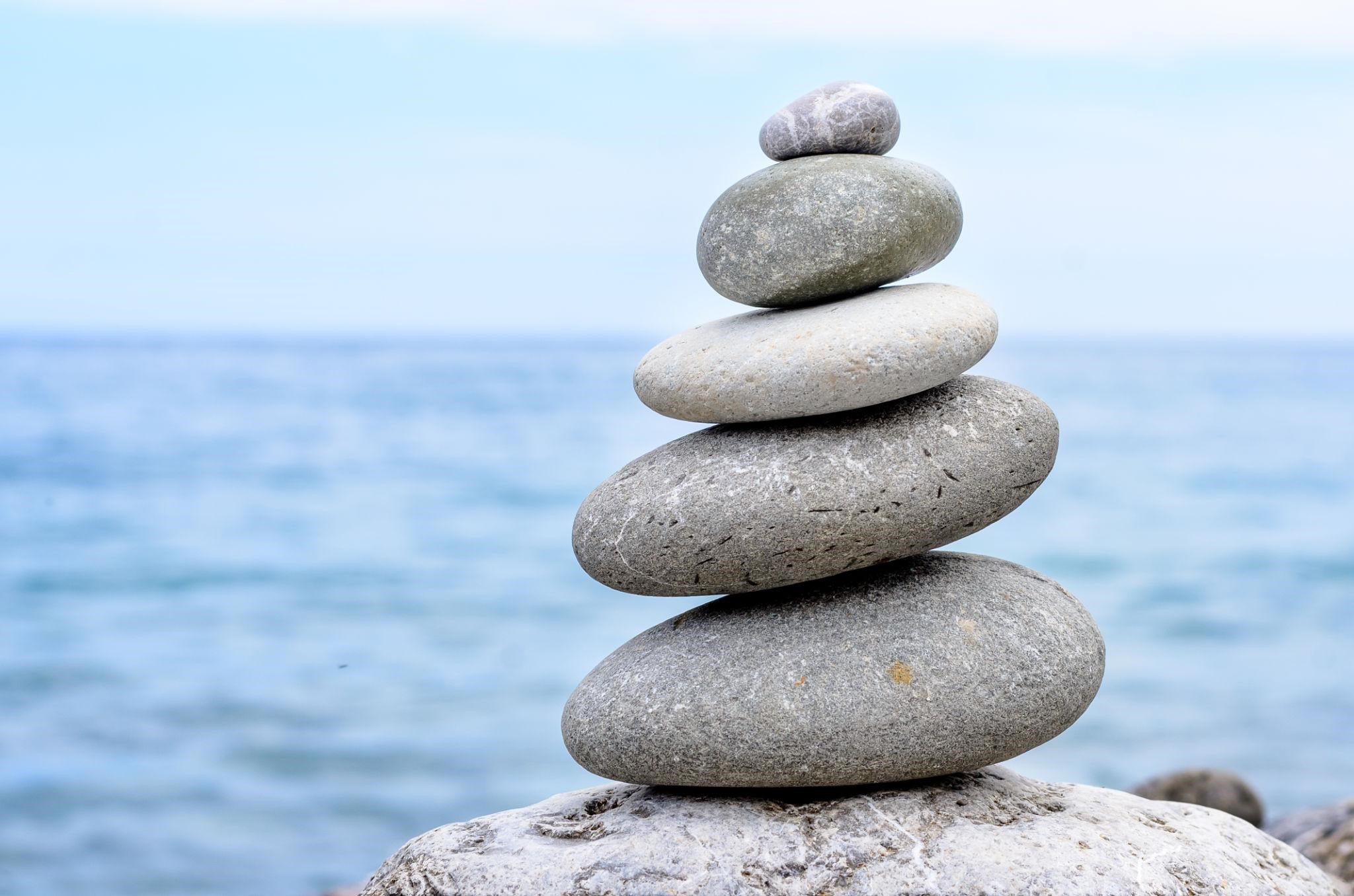 Balanced stones with the sea behind